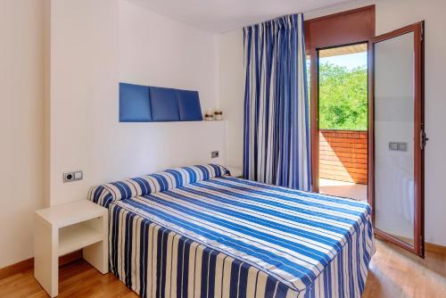滨海托萨Tossa dreams的一间卧室设有一张床和一个滑动玻璃门