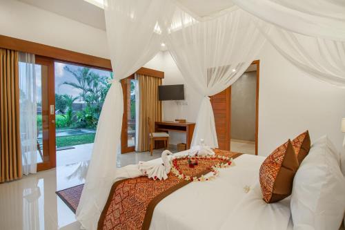 德格拉朗Palasari Villa的一间卧室配有一张带天蓬的白色床