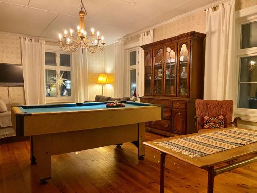 内斯比恩Apotekbygget的客厅配有台球桌和吊灯。