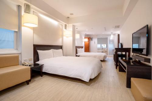 高雄承携行旅-高雄新崛江馆的酒店客房设有两张床和一台平面电视。