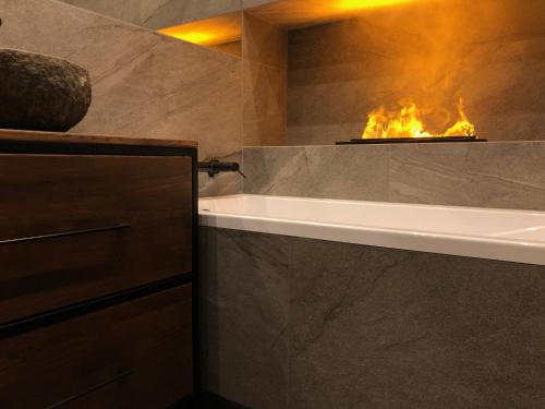 维托韦Prywatna Sauna i jacuzzi! Tatra Spa Witów的浴室配有浴缸和壁炉