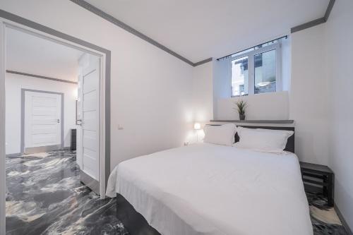 维尔纽斯Klaipedos Apartment - Lollo Luxury的白色的卧室设有一张大床和一个窗户