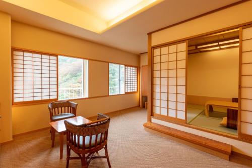 会津若松Ooedo Onsen Monogatari Higashiyama Grand Hotel的配有桌椅和镜子的客房
