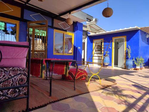 马拉喀什Riad dar sahrawi的色彩缤纷的房屋,在庭院设有桌子