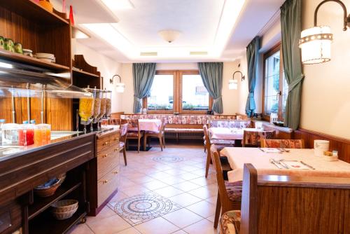利维尼奥Hotel Garni Rin Da Rin的一间在房间内配有桌椅的餐厅
