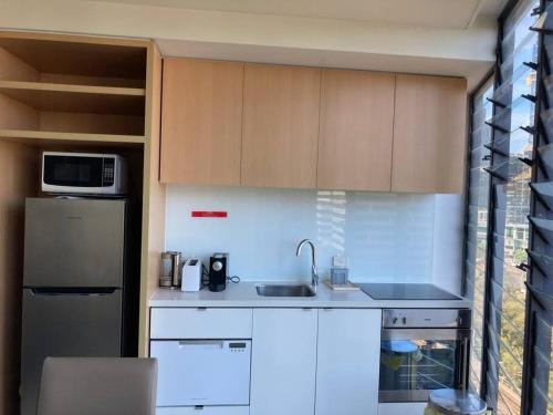 墨尔本Stylish , CBD , Views的厨房配有水槽和冰箱