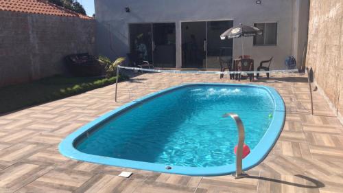 阿西斯Área de lazer Simões的一座房子旁的院子内的游泳池