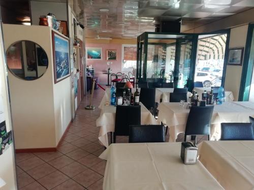 洛阿诺HOTEL GIORDANA的一间设有白色桌椅的用餐室