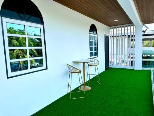 北赖Three Homestay的绿色地毯和桌椅的房间