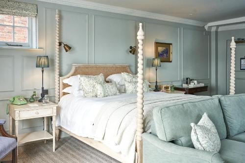 利明顿Stanwell House的一间卧室配有天蓬床和沙发