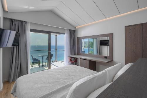 帕诺尔莫斯斯科派洛斯Adrina Grand Hotel的一间卧室配有一张床,享有海景