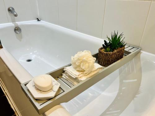伦敦Luxury Modern Canary 1 bedroom Apartment的浴室配有盥洗盆、浴缸和毛巾