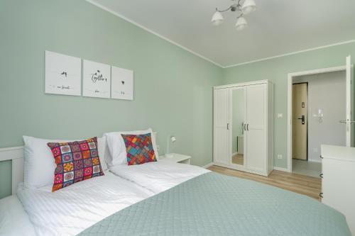 波兹南Apartment with 2 Bedrooms and FREE GARAGE Poznań by Renters的白色卧室配有一张带蓝色毯子的床