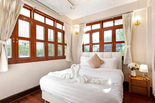 曼谷Sathorn Private Pool Villa的卧室配有白色的床铺和窗户