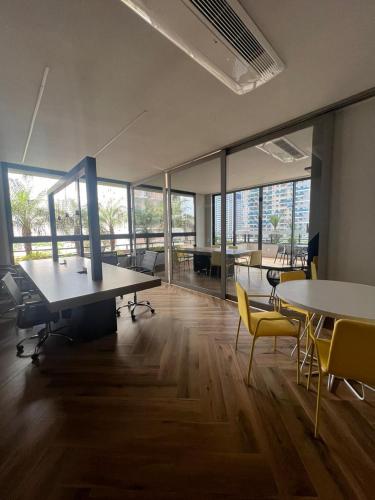 戈亚尼亚Lar no Bueno的一个带桌椅的办公室和大窗户
