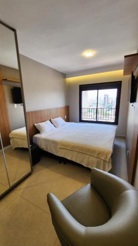 戈亚尼亚Lar no Bueno的一间卧室配有一张床、一把椅子和镜子