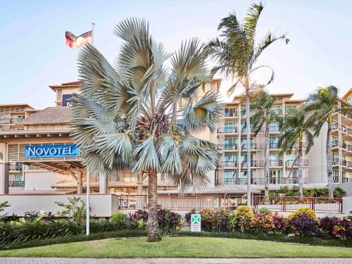 凯恩斯凯恩斯诺富特绿洲度假酒店的酒店前的棕榈树