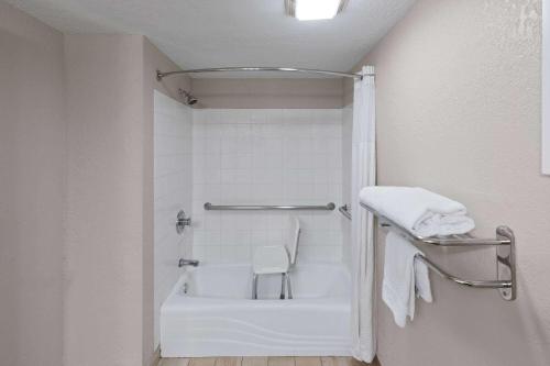俄克拉何马城俄克拉荷马城戴斯酒店及套房 的设有带白色浴缸的淋浴的浴室