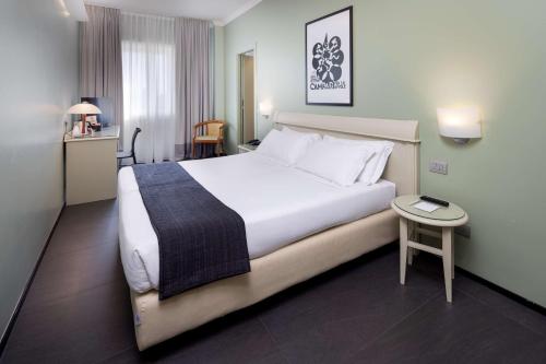 米兰贝斯特韦斯特梅捷酒店的酒店客房设有一张大床和一张桌子。