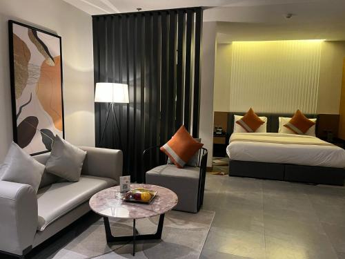 利雅德Al Muhaidb Residence Jawazat的酒店客房配有床、沙发和桌子。