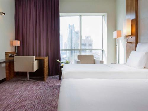 迪拜迪拜朱美拉湖塔楼普尔曼酒店的酒店客房设有两张床和大窗户。