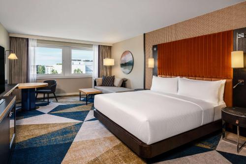 维也纳Hilton Vienna Waterfront的酒店客房设有一张大床和一张书桌。