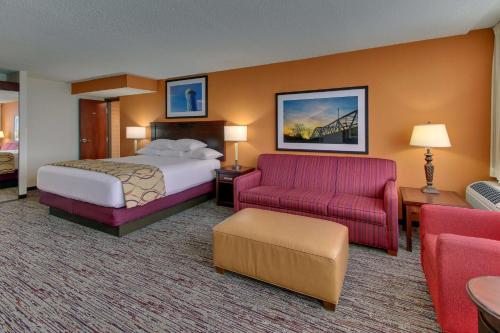 阿诺德圣路易斯-阿诺德佩特里酒店的酒店客房,配有一张床和一张红色的沙发