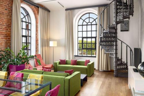 罗兹Vienna House by Wyndham Andel's Lodz的客厅设有绿色沙发和窗户
