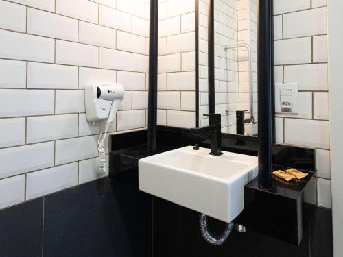 巴拉-杜加萨斯ibis Barra do Garcas的浴室设有白色水槽和镜子