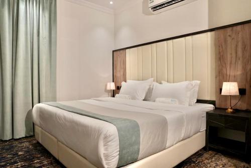 吉达لحظات الفندقية حراء Lahdat Serviced Apartments的卧室配有一张大白色的床和大床头板