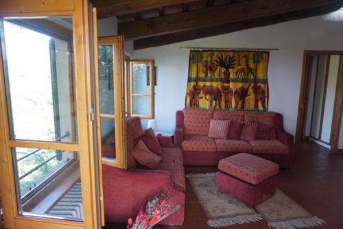 塞拉瓦莱皮斯托耶塞Casa Tre Pini的客厅设有红色的沙发和窗户。