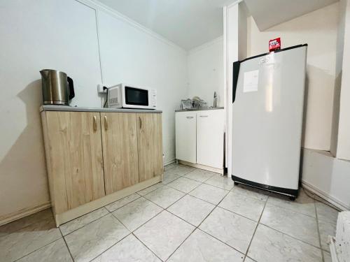 奥索尔诺Nómada Hostel Osorno的厨房配有冰箱和微波炉。