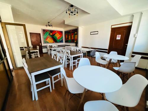 奥索尔诺Nómada Hostel Osorno的用餐室配有桌子和白色椅子