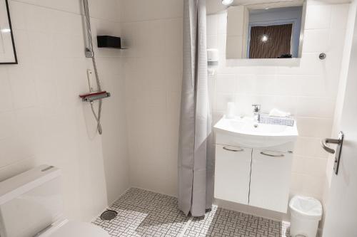 海宁海宁酒店的白色的浴室设有水槽和淋浴。