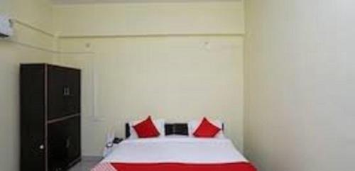 Hotel YOGIRAJ LODGING BOARDIING,Deulgaon Raja的一间卧室配有红色枕头的床