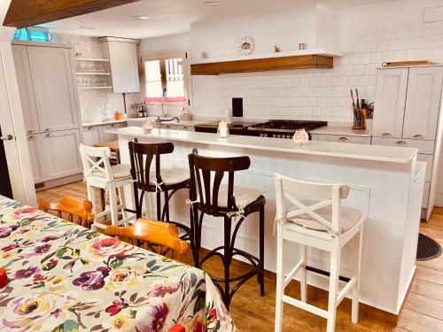 安普埃罗Los Respigos de la Pradera的厨房配有白色橱柜和带凳子的台面