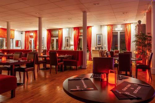 维泰勒Providence Hotel的一间带桌椅和红色窗帘的餐厅
