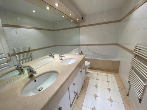 阿卡雄Appartement Arcachon, 3 pièces, 4 personnes - FR-1-374-71的浴室配有两个盥洗盆和浴缸。
