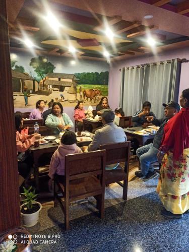 索拉哈Hotel Namo Buddha的一群坐在房间里桌子的人