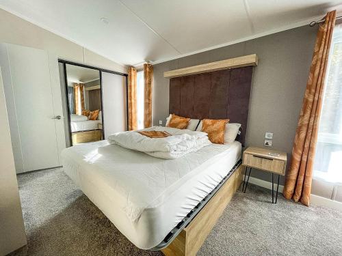 亨斯坦顿Stunning Lodge With Decking Nearby Hunstanton Beach, Sleeps 6 Ref 23215k的一间卧室设有一张大床和一个窗户。