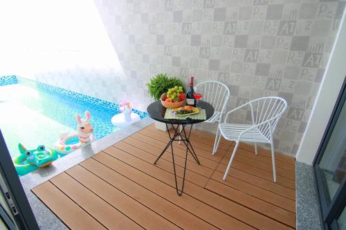 头顿Sea Villa View Biển - Đi Bộ Ra Biển的配有桌椅和游泳池的客房