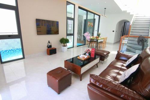 头顿Sea Villa View Biển - Đi Bộ Ra Biển的客厅配有真皮沙发和桌子