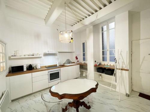 克莱蒙费朗La Flânerie Centre Historique的一间白色的厨房,中间设有一张桌子