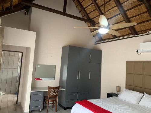 玛洛斯帕克Kruger Nest的一间卧室配有一张床、一张桌子和吊扇