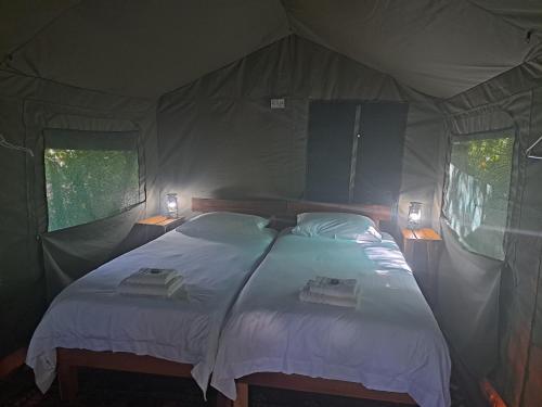 维德尼斯Woodcutter's Bush Camp at The Old Trading Post的帐篷内一间卧室,配有一张床