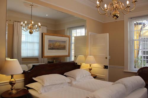 开普敦廷塔哲旅馆的一间卧室配有两张床、两盏灯和吊灯。