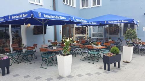 多瑙沃特特劳贝珀斯特酒店的一个带桌椅和蓝伞的庭院