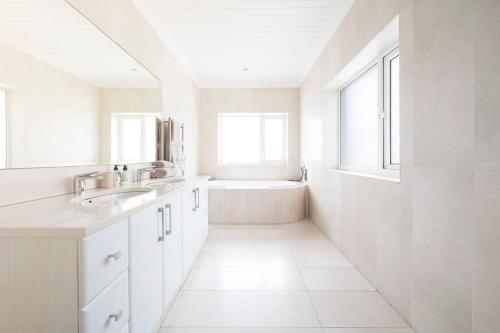 SkoenmakerskopThe Cabin on the Rock的白色的浴室设有浴缸和水槽。