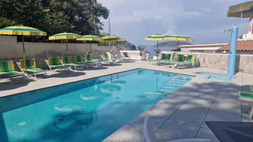 伊斯基亚达玛丽亚酒店的一个带椅子和遮阳伞的游泳池