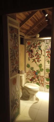 伊瓦格Hospedaje Rural Tupinamba的一间带卫生间的浴室和墙上的绘画作品
